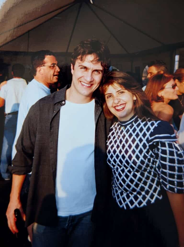 Homem e mulher sorrindo e posando juntos em uma festa ou evento social