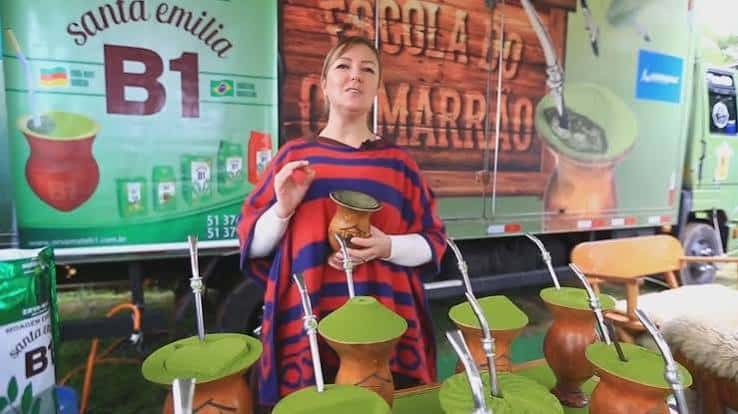 Mulher apresenta cuias e bombas de chimarrão em uma exposição cultural