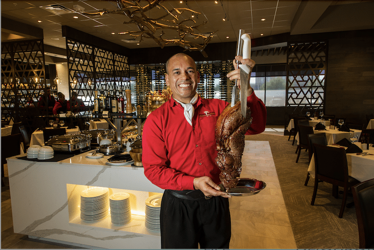 Garçom servindo costela assada em restaurante
