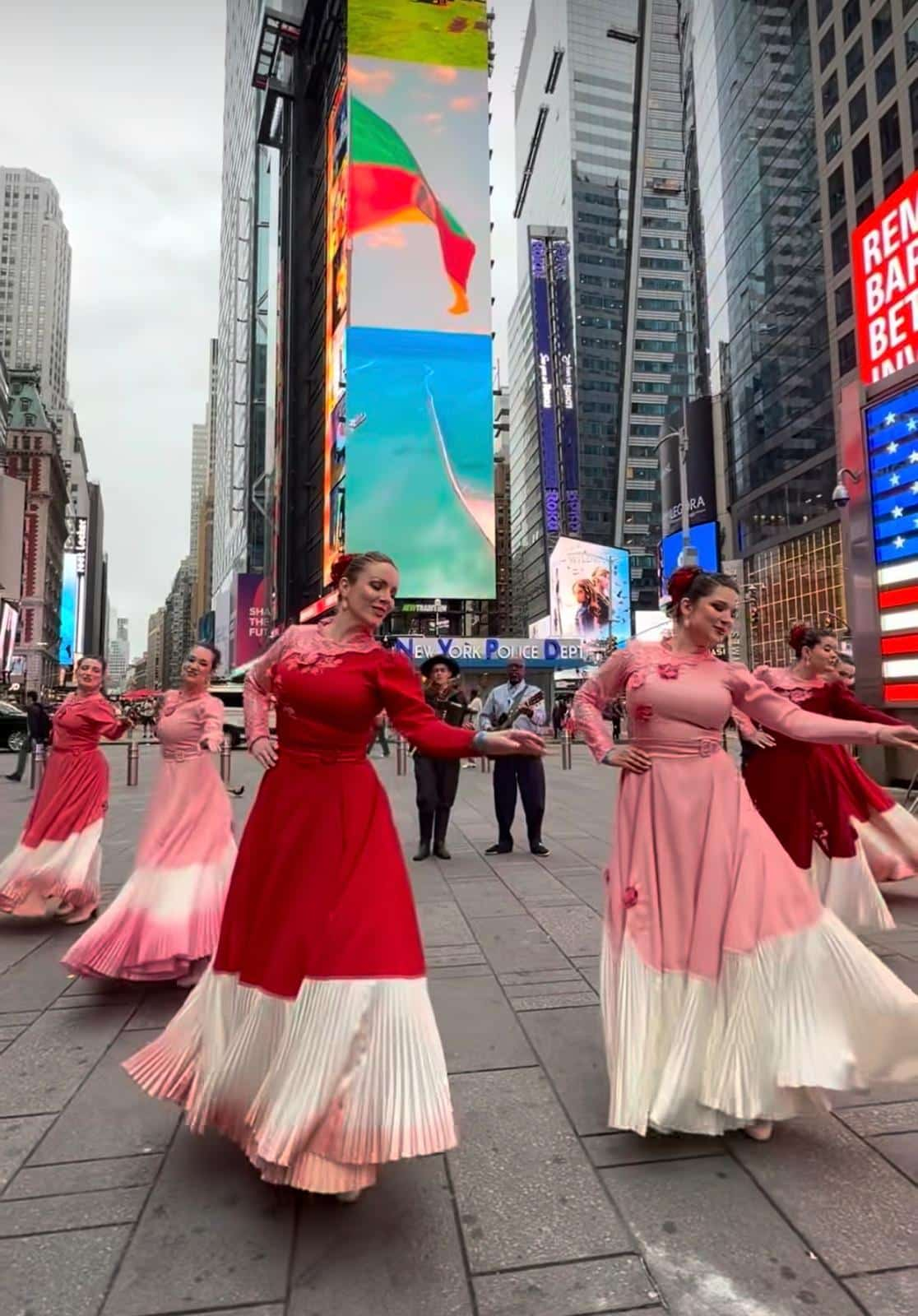 Dançarinas com vestidos tradicionais vermelhos e rosas se apresentam na Times Square.